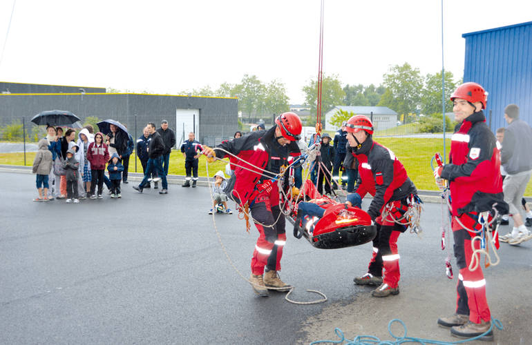 La photo montre un exercice d'évacuation par les pompiers.