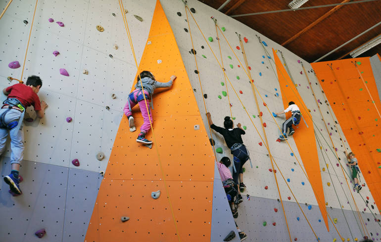 Vue de 4 enfants sur un mur d'escalade.