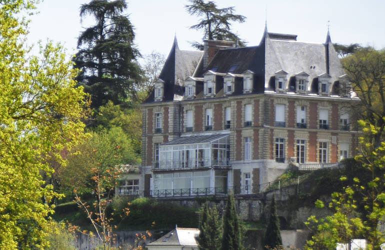 Vue sur le bâtiment du Centre Malvau entouré de végétation.