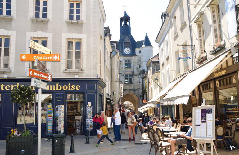 Entrée de la rue Nationale avec vue sur le Beffroi, en plein été avec commerces et promeneurs.