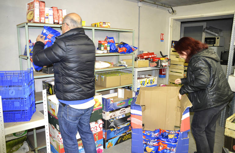 Réserve alimentaire du CCAS Deux personnes sont dans la réserve alimentaire du Centre Communal d'Action Social. Ils rangent des denrées alimentaires sur des étagères.