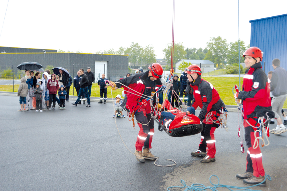 La photo montre un exercice d'évacuation par les pompiers.