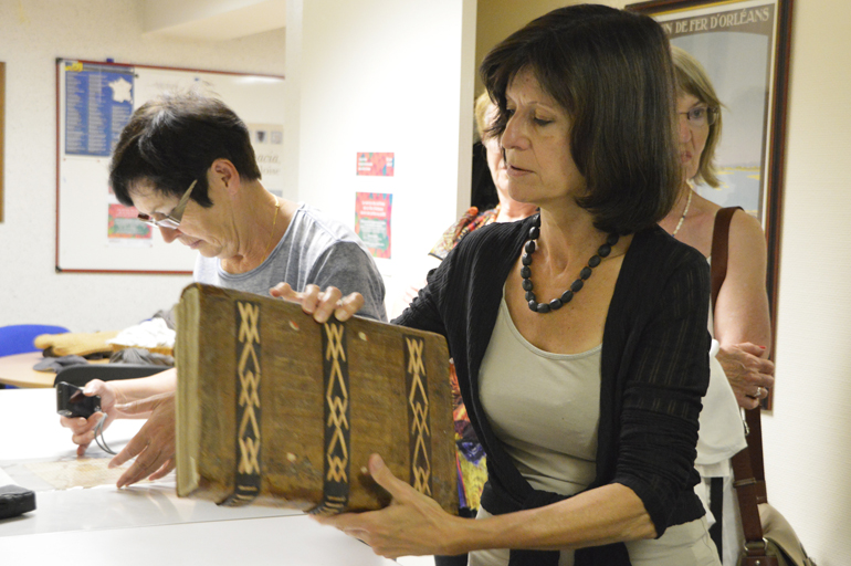 Une femme est en train de consulter des documents au service des archives de la ville d'Amboise.