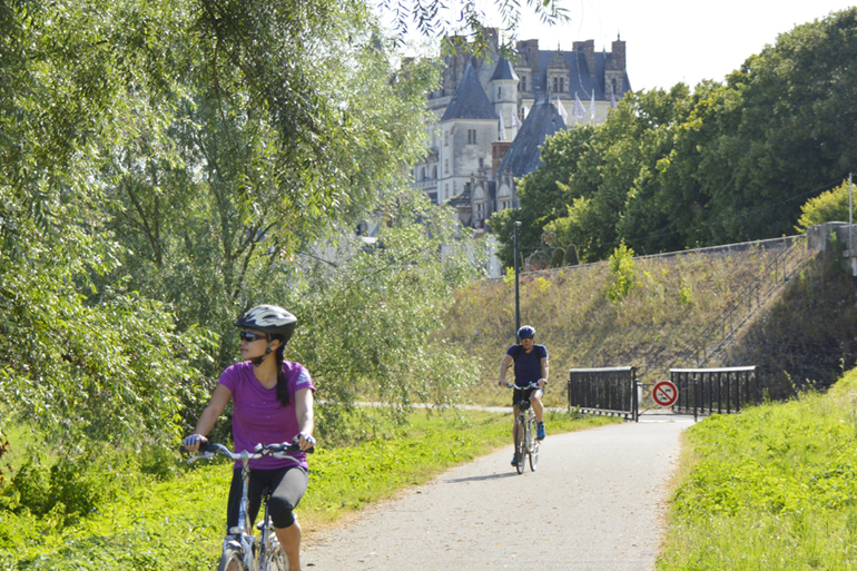 Deux personnes font du vélo sur le chemin de La Loire à vélo.